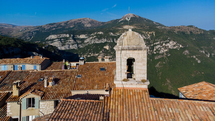 Wall Mural - Aerial view of the belltower of the church of Gourdon in Provence, France - Medieval village built on the edge of a cliff in the mountains of the Gorges du Loup on the French Riviera