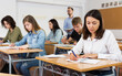 © JackF - serious schoolgirl is sitting test and answer about task in the classroom.