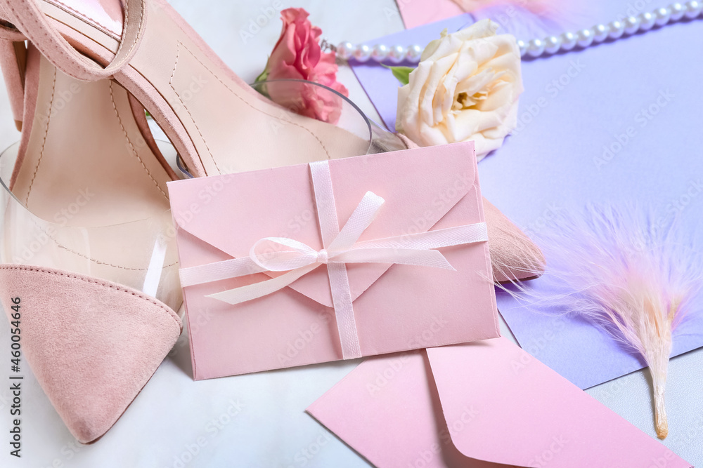 Envelope with shoes on white background, closeup