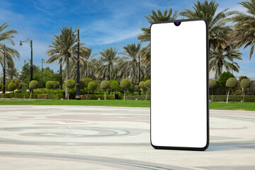 Fototapete - Big Modern Mobile Phone with Blank Screen as Template for Your Design in Empty City Street with Palm Trees. 3d Rendering
