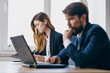 © SHOTPRIME STUDIO - business man and woman sitting at a desk with a laptop communication finance officials
