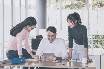 Wall Mural - Asian business team who consulting at the office with daylight from window and blur garden background.