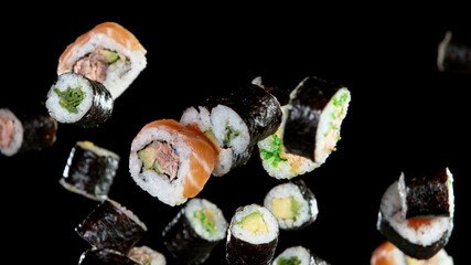 Poster - Freeze motion of flying sushi pieces on black background