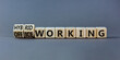 Hybrid or office working symbol. Turned wooden cubes and changed words 'office working' to 'hybrid working'. Beautiful grey background. Business, hybrid or office working concept, copy space.