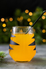 Wall Mural - orange mandarin cocktail in glass with black stripes. Christmas holiday welcome drink. Concept for children new year