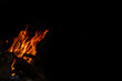 © Rocio - Fire or campfire lit. High flames with sparks. Half of the image in black with space for writing. Photo for design, wallpaper, text.