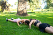 © luisrojasstock - two young caucasian girls practicing push-ups in a park on a sunny day