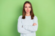 © deagreez - Photo of cool young brunette lady crossed arms wear blue pullover isolated on green color background