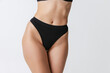 © master1305 - Beautiful body of young slim woman in black lingerie, panties isolated on gray studio background. Natural beauty concept. Bottom view