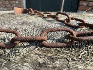 Wall Mural - Closeup shot of a rusty metal chain on the floor