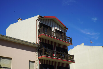 Wall Mural - Beautiful beige building with red stripes and balconies under the blue sky