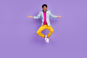 Wall Mural - Photo of carefree funny guy jump raise hands weekend free time wear blue shirt isolated purple color background