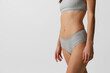 © master1305 - Beautiful body of young slim woman in grey lingerie, panties isolated on gray studio background. Natural beauty concept. Bottom view
