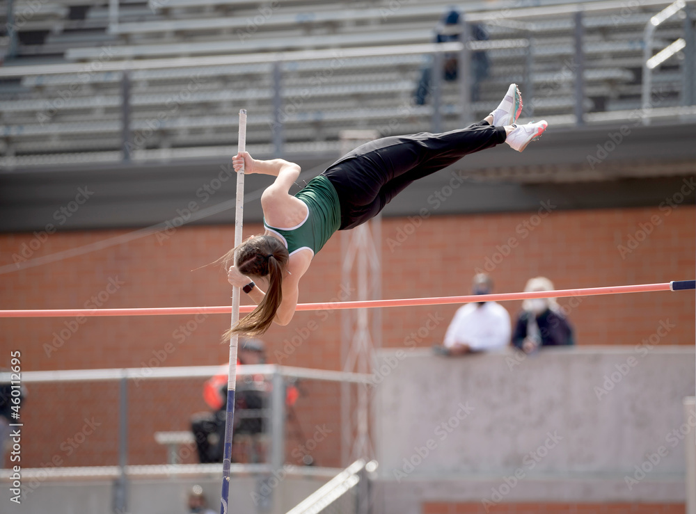High School girls competing in pole vault at a track and field meet ...