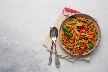 Whole wheat pasta with tomato sauce, fresh tomatoes and basil. Top view, empty space