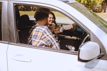 Wall Mural - couple having chocolate snack while riding in car