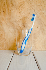 Wall Mural - Toothbrush stands in a glass on a beige background
