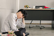 © SHUTTER DIN - young businessman sitting on the floor stressed sad after being laid off from his job