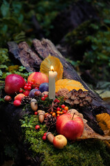 Poster - candle, fruits and nuts on natural forest background. magical esoteric ritual. altar for mabon sabbat. Mysticism, wicca, occultism, Witchcraft concept. symbol of autumn harvest. Thanksgiving holiday