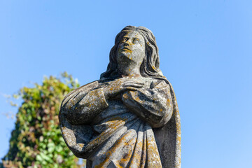 Wall Mural - The sculpture of the Mother of God is made of stone. Monument in the Christian cemetery.