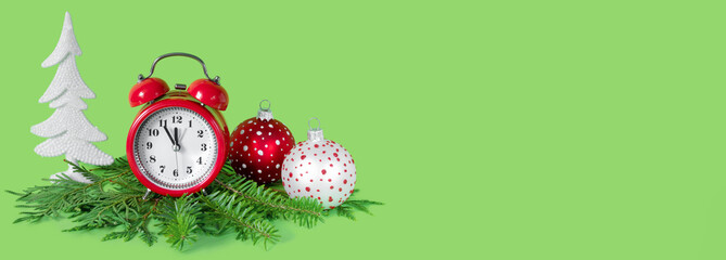 Wall Mural - Red and white Christmas balls, alarm clock and tree branches on green paper background. 5 minutes before the New Year.