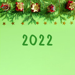 Wall Mural - Red gift boxes with gold braid and branches of New Year tree on green paper. Creative christmas background with copy space for text.