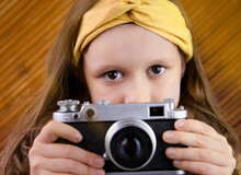 A Girl With A Photo In Her Hands. Children's Hobbies