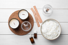 Flat Lay Composition With Homemade Candles And Ingredients On White Wooden Background