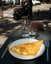France, Paris, Crepes With Banana Slices On Plate Outdoors