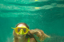 Spain, Mallorca, Smiling Woman In Scuba Mask Diving In Sea