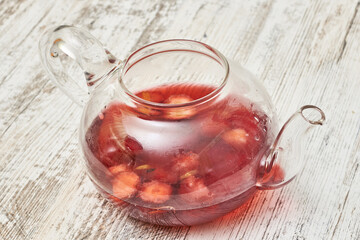 Canvas Print - Fruit tea into a glass teapot on a wooden table