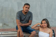 © Hector Pertuz - Young couple sitting on a park bench and looking at the camera.