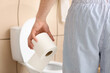 Young man with toilet paper in bathroom, closeup