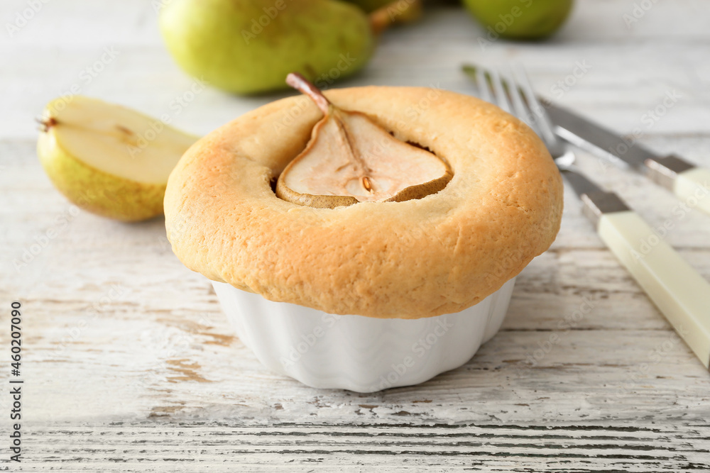 Tasty pear pot pie on light wooden background
