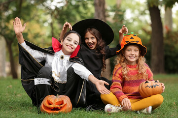 Cute little children in Halloween costumes outdoors