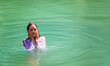 Christian Pilgrim girl take a symbolic baptism in the Jordan River in North Israel (Yardenit Baptismal Site)