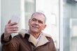 © tetxu - mature man in winter jacket taking a selfie with the phone
