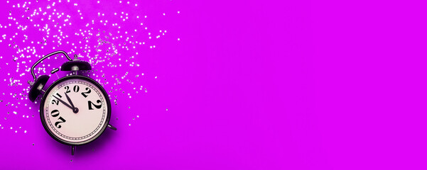 Wall Mural - New Year 2022 banner background concept. 2021 changes to 2022 on an alarm clock on a pink background with festive glitter on New Year's Eve and Christmas.