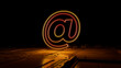 © RocknRoller Studios - Orange and Yellow Email Technology Concept with @ symbol as a neon light. Vibrant colored icon, on a black background with high tech floor. 3D Render