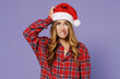 Puzzled thoughtful pensive gloomy confused pop-eyed young Santa woman 30s wears shirt Christmas hat looking camera rubbing temple head isolated on plain pastel light violet background studio portrait.