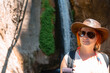© Sergey - Traveler girl with leather hat and backpack posing at the sapadere canyon and waterfall, Nature, Travel and vacation concept. Summer sunny day. Alanya turkey