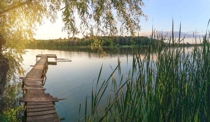 Wall Mural - lake panorama with fishing pier at sunset