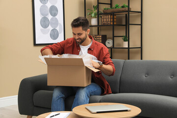 Canvas Print - Man unpacking parcel at home. Online shopping