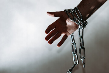 Hand with chain hang,chain in hand,the chain wound on the hand,gray background.Copy space.