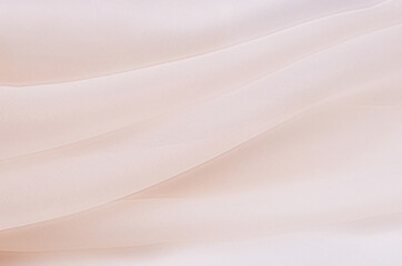 Texture, background, pattern. Texture of light beige or pink silk or cotton or wool fabric. Beautiful pattern of fabric.