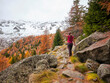 © trattieritratti - Girl during a hike in the mountains in the woods of Valtellina in Italy, with autumn colors. Reflection of autumn foliage in the woods of the Val Masino mountains in Lombardy in Italy