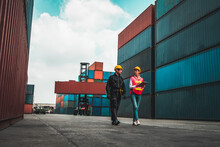Industrial Worker Works With Co-worker At Overseas Shipping Container Yard . Logistics Supply Chain Management And International Goods Export Concept .