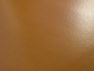Wall Mural - brown smooth glossy material with blank copy space, paper or cardboard with a characteristic ribbed texture and a spot of light on the surface, milk chocolate shade empty backdrop