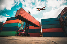 Cargo Container For Overseas Shipping In Shipyard With Airplane In The Sky . Logistics Supply Chain Management And International Goods Export Concept .