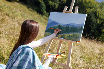 Poster - Young woman drawing on easel with brush outdoors